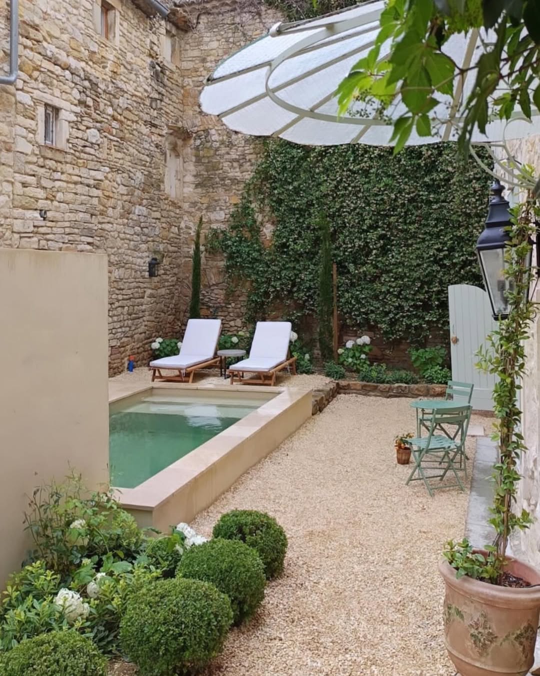 mini piscine fauteuils murs pierre végétal