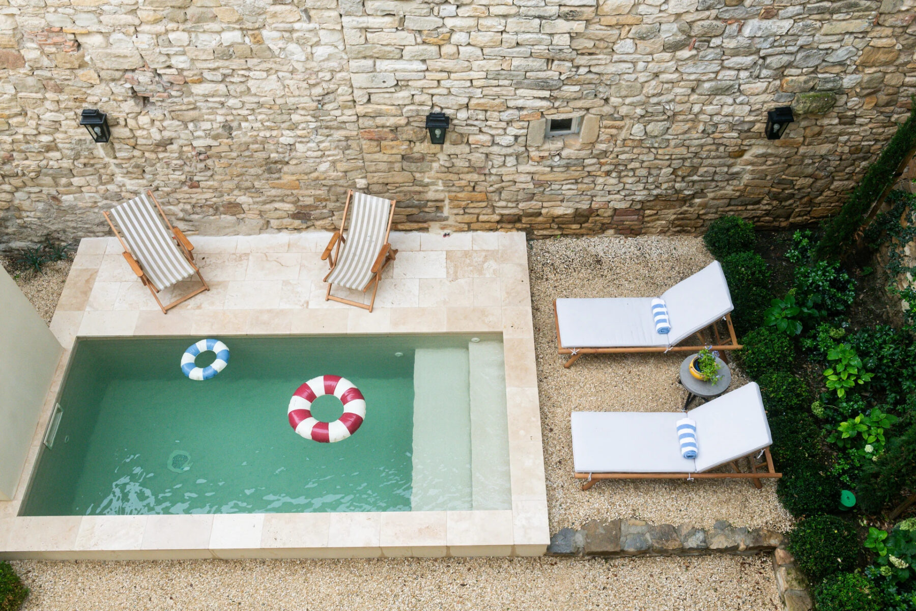 mini piscine fauteuils murs pierre bouees plage immergée