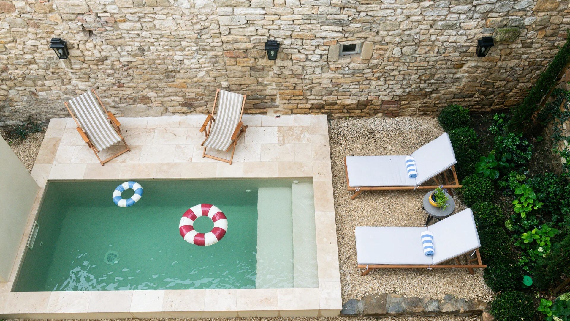 mini piscine fauteuils murs pierre bouees plage immergée